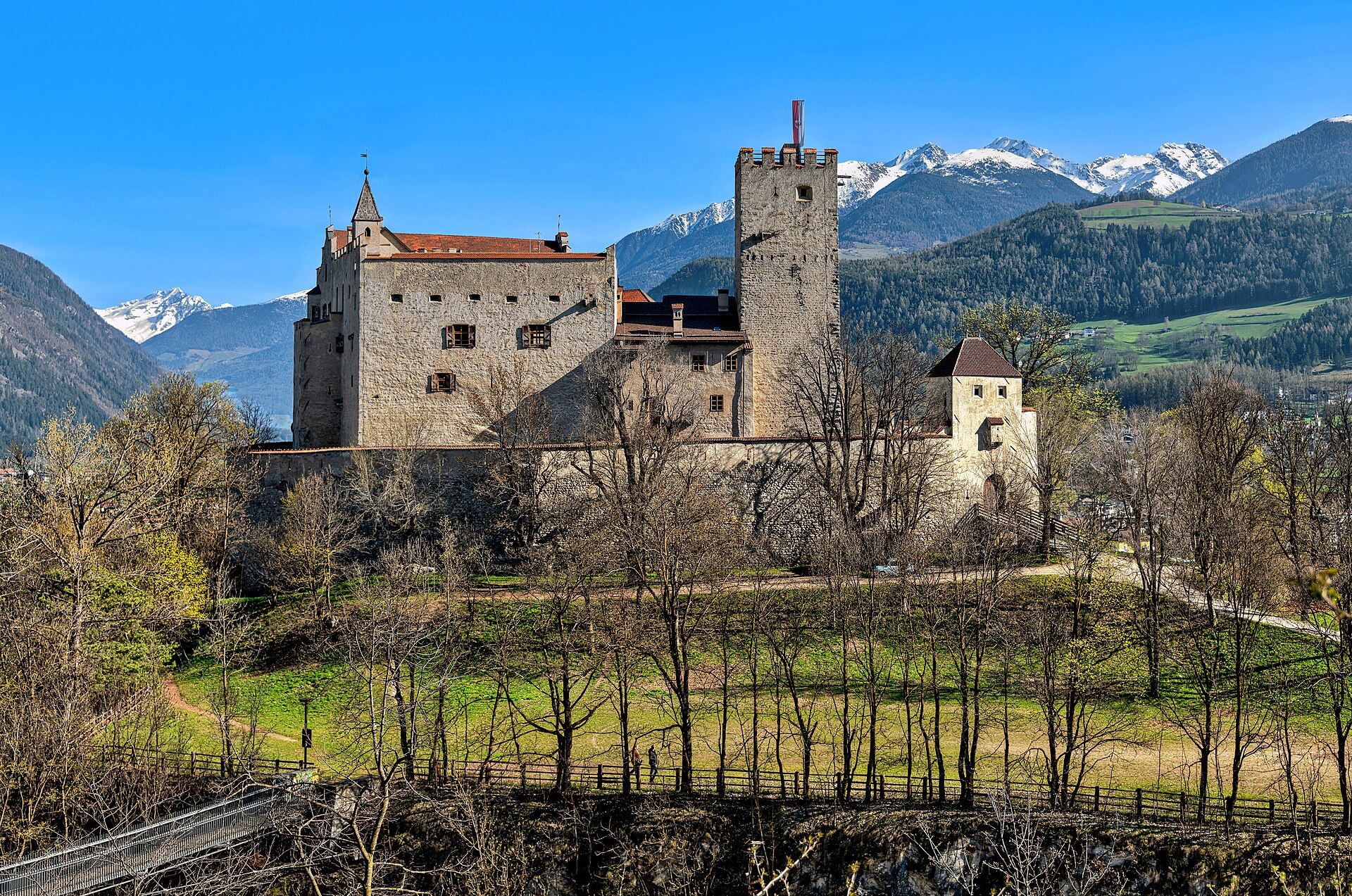 Schloss Bruneck im Frühling, dahinter verschneite Gipfel